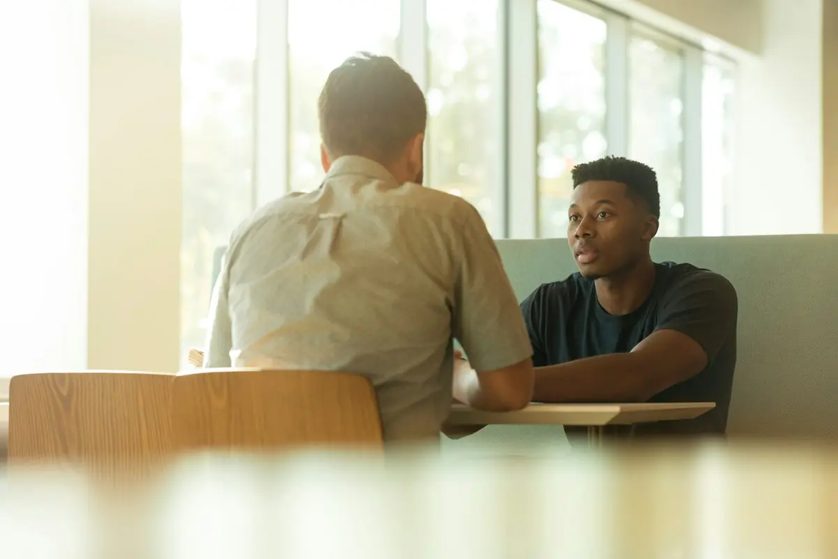 Deux personnes en discussion autour d'une table