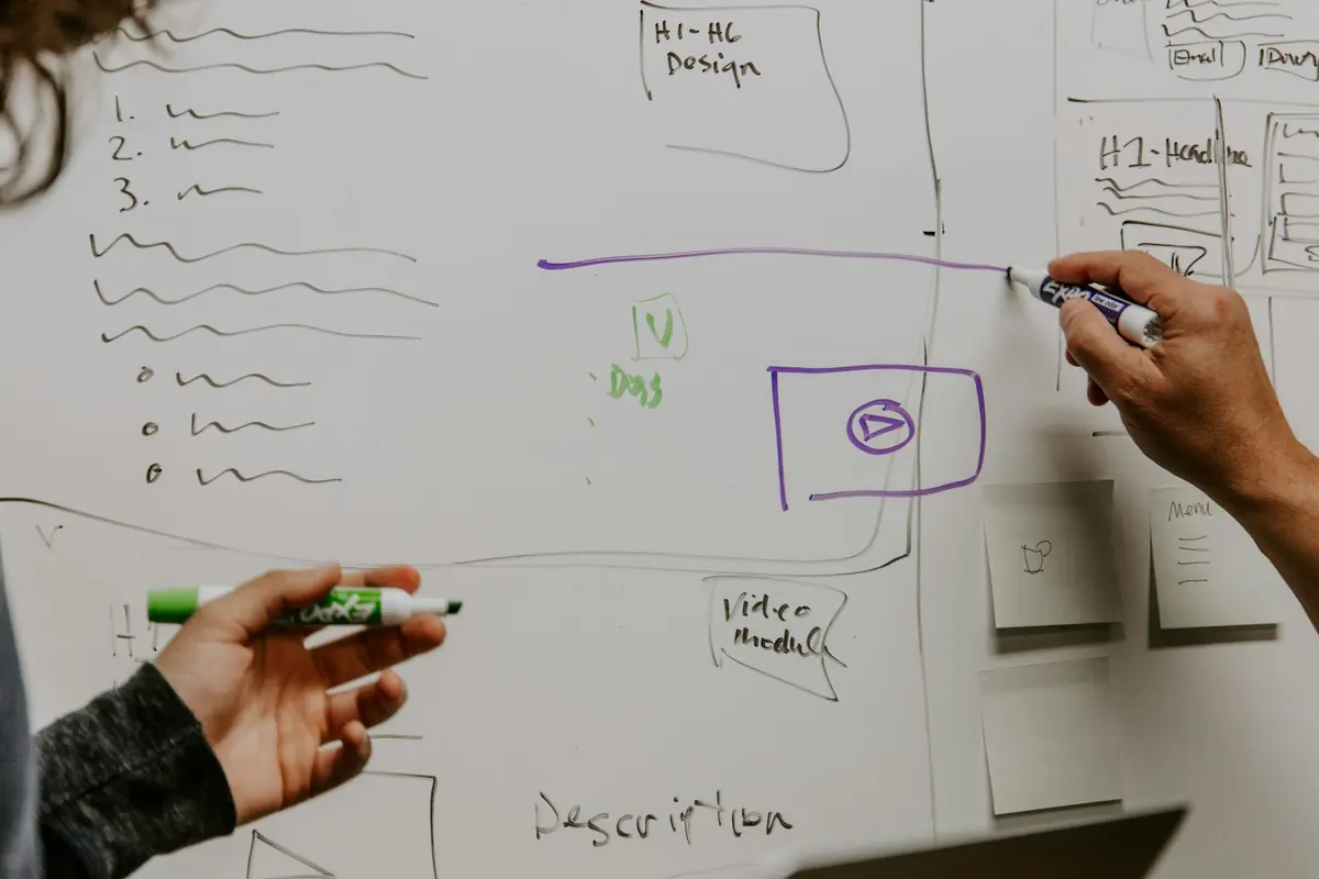 Deux personnes préparent un plan sur un tableau blanc